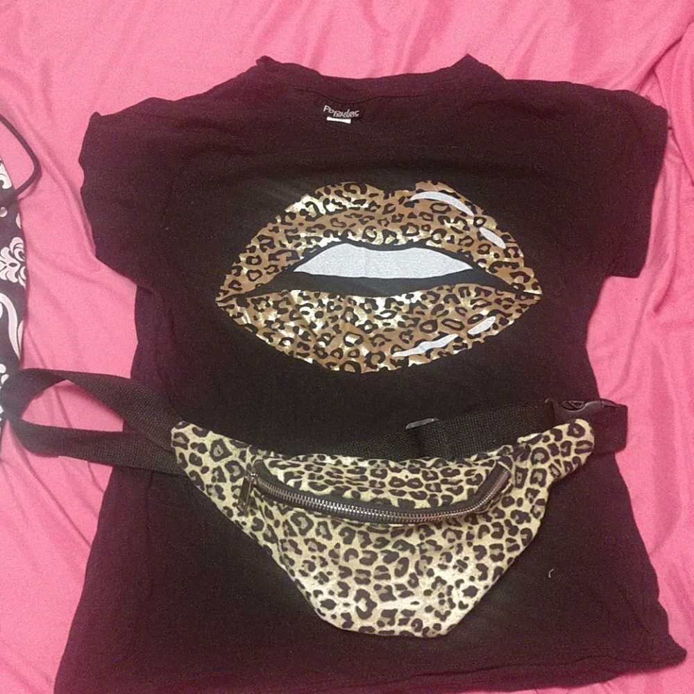 A black plan shirt with lips on it and fanny pack